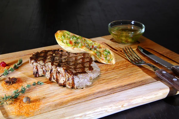 Beef steak medium rare on vegetable cushion. Beef steak on wooden plate plate - Stock Image