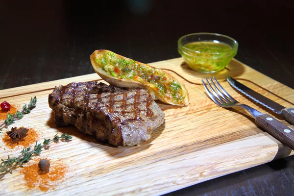 Beef steak medium rare on vegetable cushion. Beef steak on wooden plate plate - Stock Image
