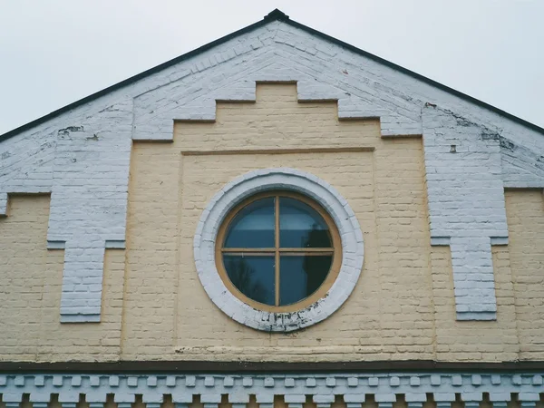 Roof of the building with a round window