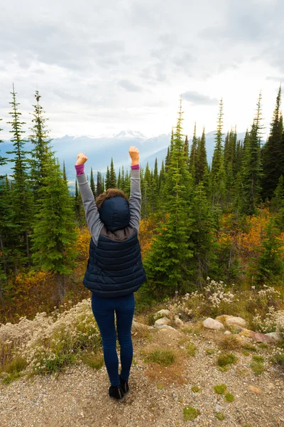 Girl with hands in the air in a mountanous scenery