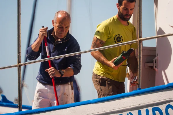 Palamos, Catalonia, may 2016: fisherman cleaning and repairing the vessel
