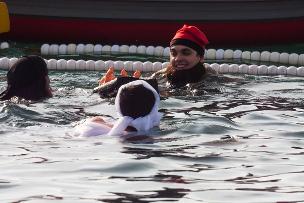 CHRISTMAS DAY HARBOUR SWIM 2015, BARCELONA, Port Vell - 25th December:Swimmers in carnival costumes greet the audience