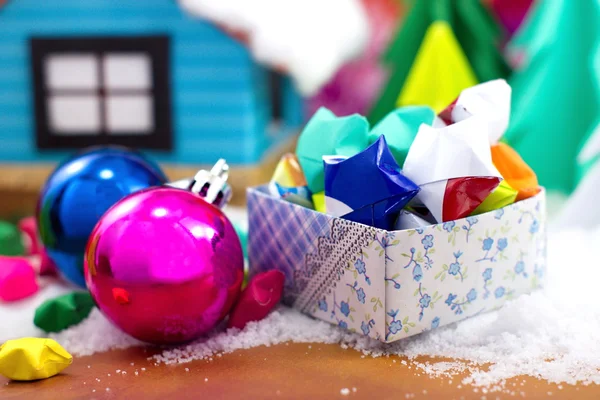 Paper stars in a gift box and Christmas ball on the snow