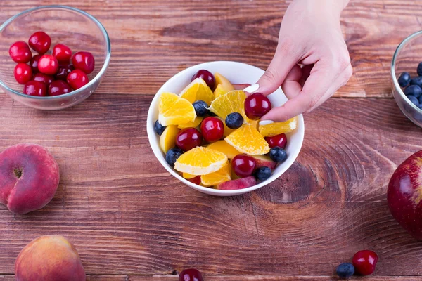 The person cooks fruit salad.