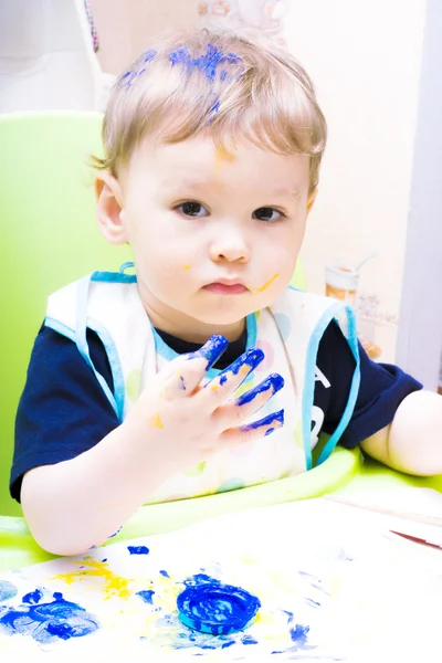 Cheerful boy with painted face and hands