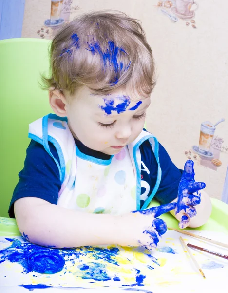 Cheerful boy with painted face and hands