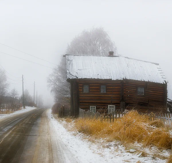 The wooden log house, early 20th century. Karelian village Mashezero. Winter, a misty morning.