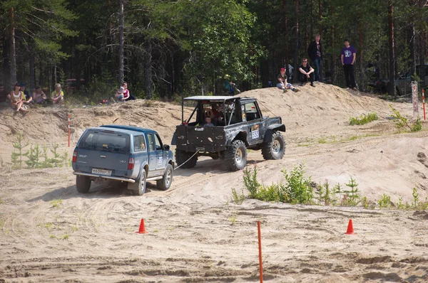 A damaged car is towed on a sandy track. Off-road racing. Girvas 18.07.2015. SUVs, Jeeps, ATVs. Summer, Sand.