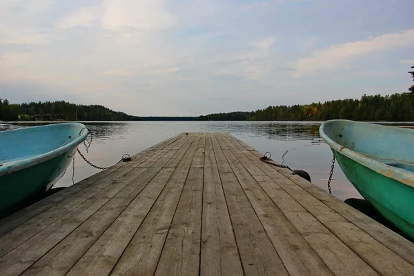 A smooth lake, pier, boat