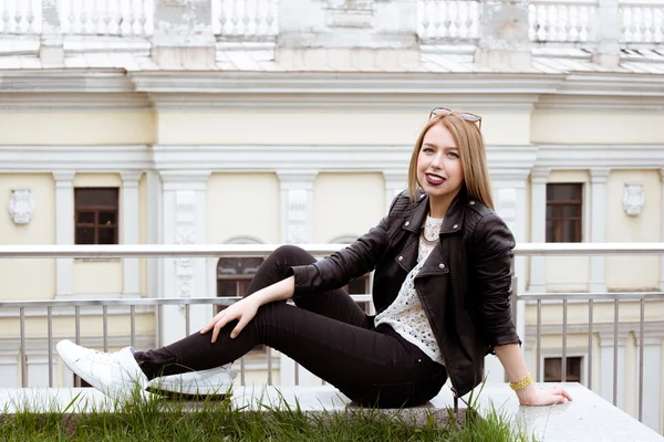 Young blonde woman in red lumberjack shirt, jeans and sneakers