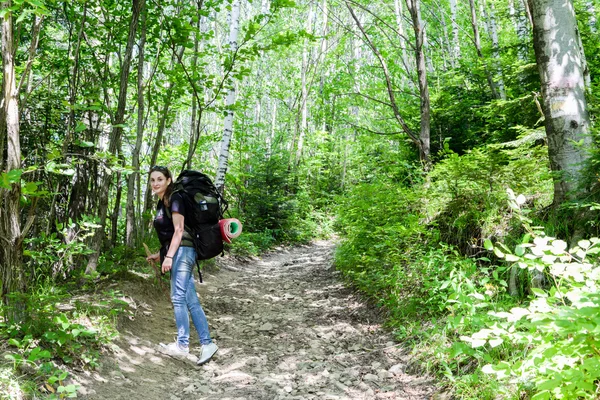 Young woman hiking with backpack in forest