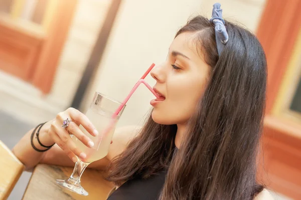 Gorgeous young brunette drinking lemonade