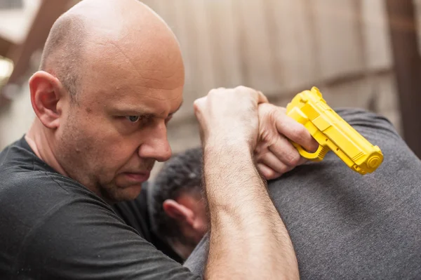 Gun Disarm. Self defense techniques against a gun point.