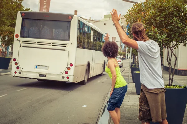 Young couple waving goodbye to their friends on the bus