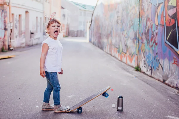 Young skater by the graffiti wall