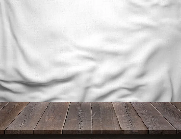 Wood table with white cotton fabric background