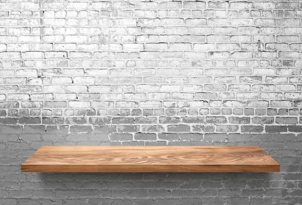 Wooden shelf on white brick wall