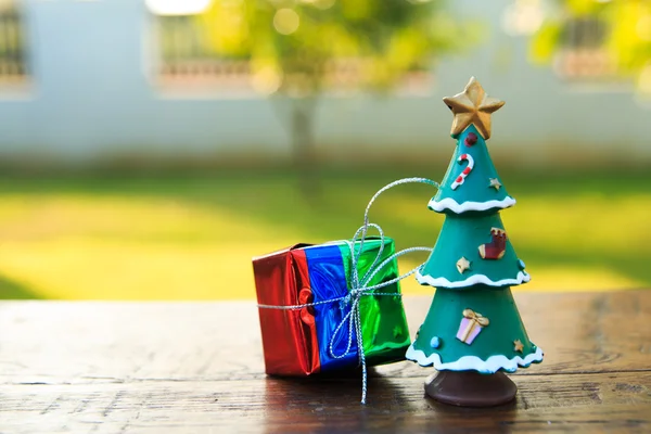 Gift with Christmas Tree  on wood table ,in garden background