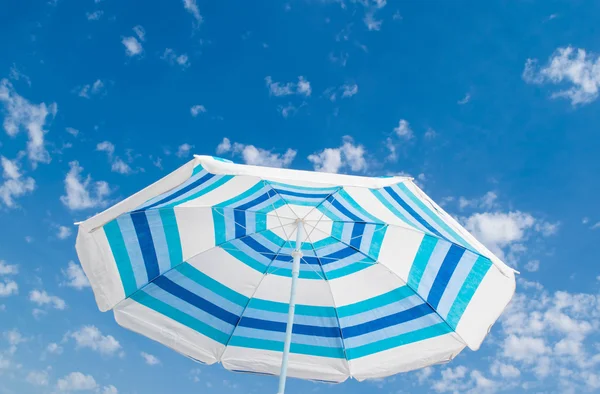 Striped beach umbrella above blue sky, vacation