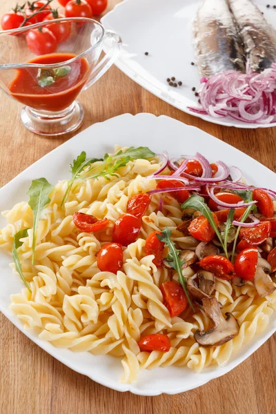 Pasta with mushrooms, cherry tomatoes and tomato sauce, italian food. Closeup