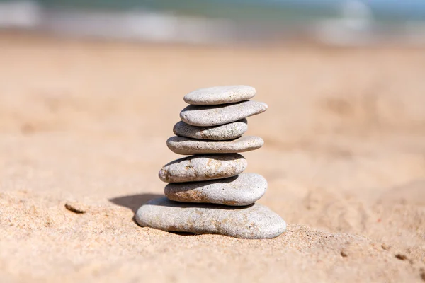 Balance zen stones pyramid on the sea sand