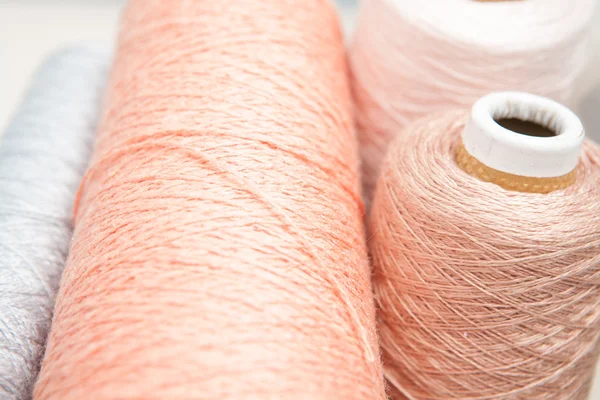 Spools of thread peach color on a white background