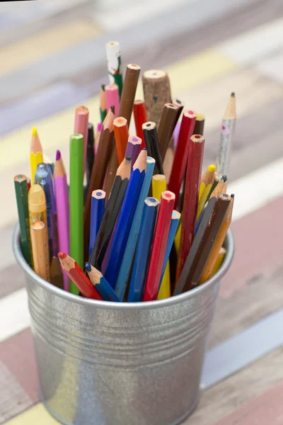 Colored pencils in a metal bucket.