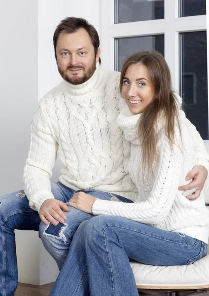 Portrait of husband and wife in white sweaters.