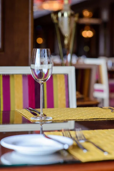 Wineglass standing on the decorated table in the restaurant before dinner