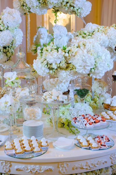 Wedding dessert table with cakes and white flowers