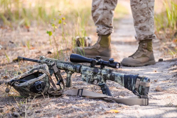 Rifle and soldier's helmet lay on the ground