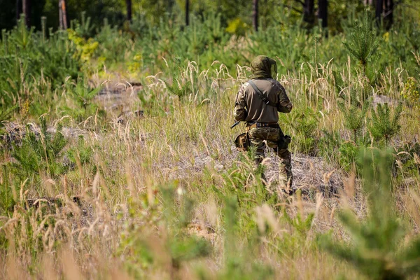 Armed soldier in camouflage on patrol in the field