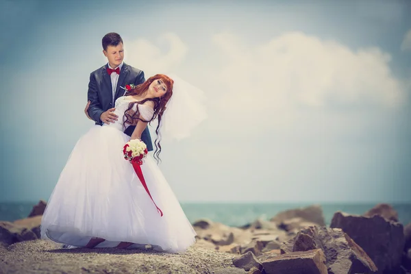 Wedding: bride and groom by the sea