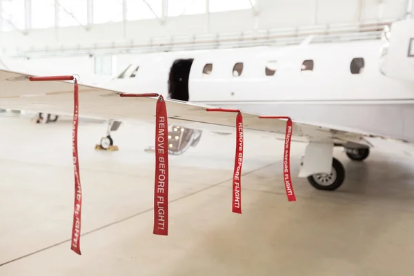 Airplane in Hangar with remove before flight Labels in red