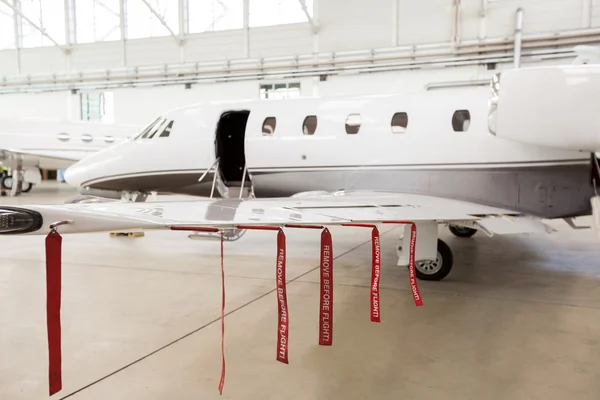 Airplane in Hangar with remove before flight Labels in red