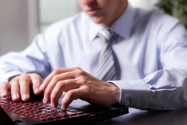 Young man working on the computer.Hands in the foreground.