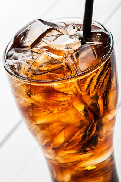 Alcoholic cocktail with cola and ice on white background closeup