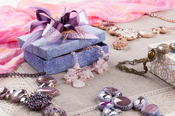 Female jewelry and gift box on linen tablecloth