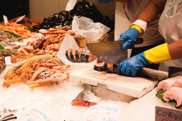 Fish vendor cuts fish on the market