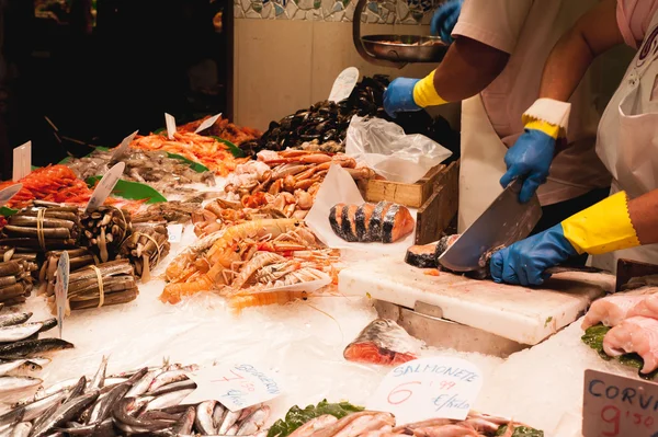 Fish vendor cuts fish on the market