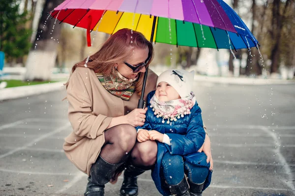 Mother and daughter under umbrella