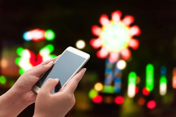 The women using smart phone on blurred light street