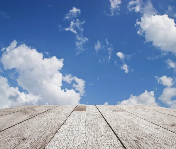 Wooden table top on blue sky with cloud