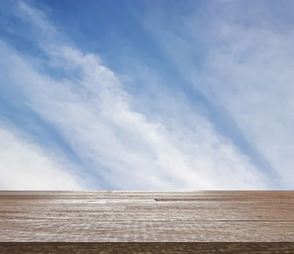 Wooden table top on blue sky with cloud