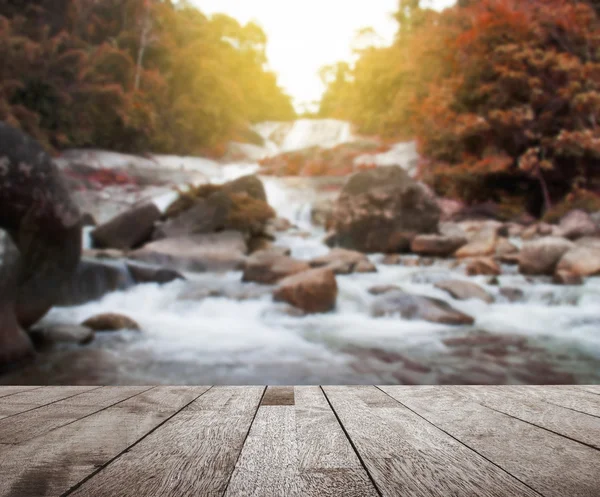Wood floor top on blurred colorful water fall