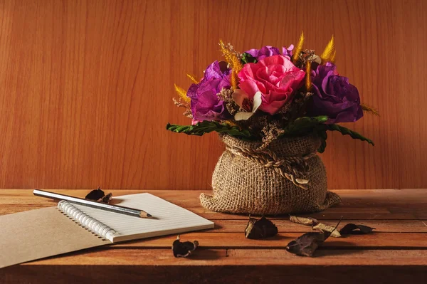 Table of writer, Notepad with pencil and flower on wooden table