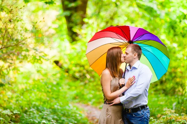 Couple in love young people hiding under an umbrella