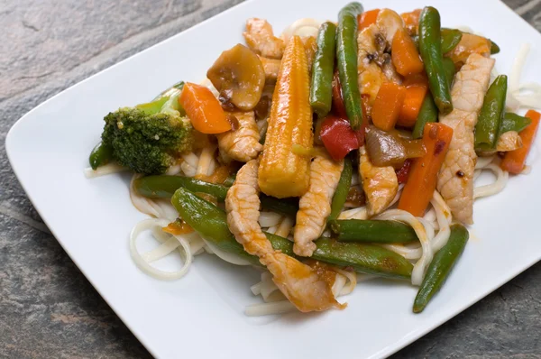 Oriental Cuisine in a White Plate on a Granite Counter