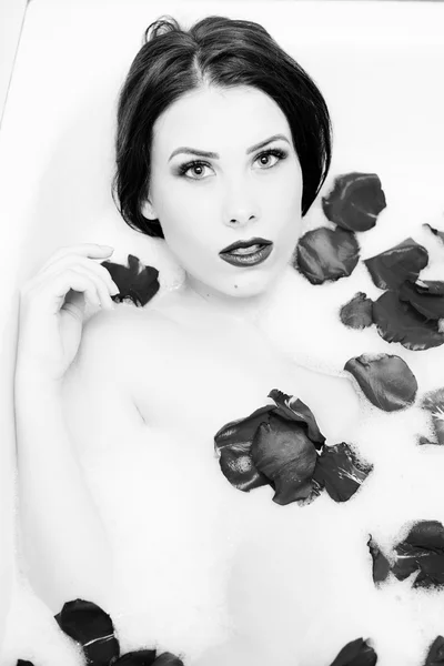 Black white photography of elegant sexy pretty girl with silk skin having fun laying in water bath relaxing