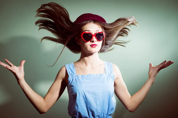 Hair blown away surprised girl with glasses in the shape of hearts